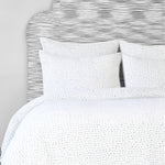 A cotton voile bed cover with a blue and white polka dot duvet cover, featuring the Organic Hand Stitched Light Indigo Quilt by John Robshaw. - 28271559442478