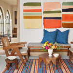A living room with a John Robshaw vintage Bench in Lanka Clay, and a colorful rug. - 29588808368174
