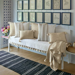 A bench with John Robshaw's Chahan Throw pillows and framed pictures. - 30003038322734