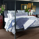 A Lapis Peacock Quilt bed with a blue and white comforter by John Robshaw. - 30003015155758