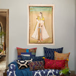 A vintage-inspired living room with a Princess With Faded Blue Sky Tapestry by John Robshaw hanging above a couch. - 30148787601454