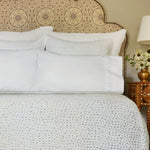 A bed with John Robshaw's Stitched Light Indigo Organic Sheets and pillows featuring embroidered designs. - 30270334042158