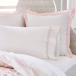 A bed with a Stitched Coral Organic Sheets comforter and pillow shams featuring embroidered designs. (John Robshaw) - 15346861572142