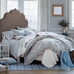 A blue and white bedroom with a Dasati Duvet Set by John Robshaw on the bed, adorned with pillows. - 11654536593454