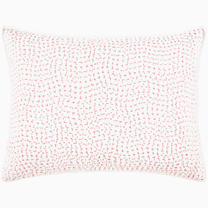 A John Robshaw Organic Hand Stitched Lotus Quilt with a pink and white pillow with dots on an organic cotton voile coverlet.