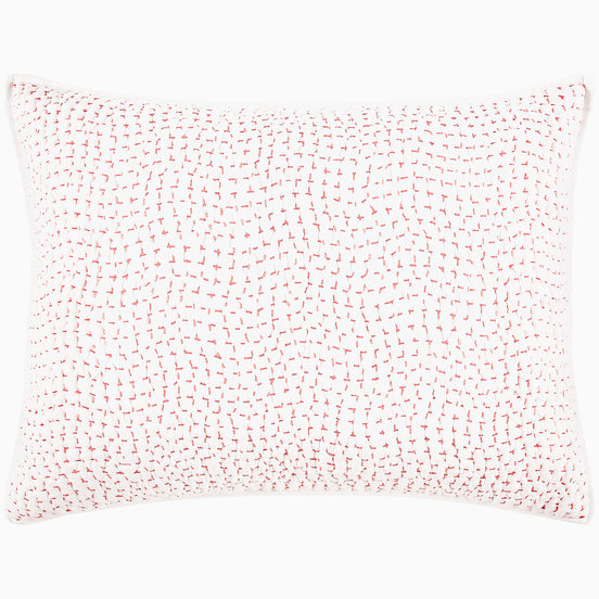 A John Robshaw Organic Hand Stitched Lotus Quilt with a pink and white pillow with dots on an organic cotton voile coverlet.