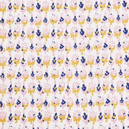 A close up of a Kiki Oyster Fabric hand block printed pink, blue and yellow flower batik by John Robshaw.
