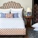 A blue and white bedroom with a bed, pillows, and John Robshaw Layla Azure Quilts.