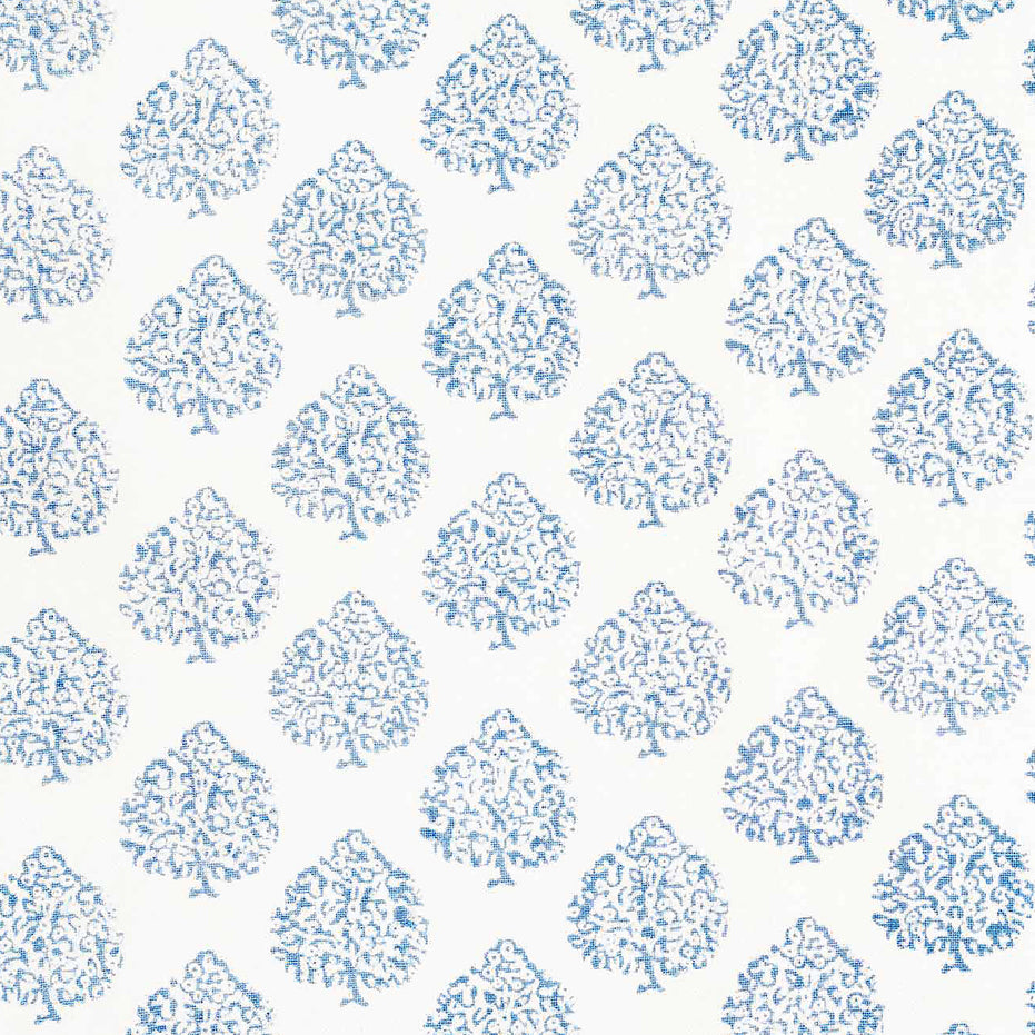This Mali Light Indigo Fabric by John Robshaw showcases a beautiful blue and white tree pattern on a crisp white background, highlighting the traditional craftsmanship involved in creating this design.