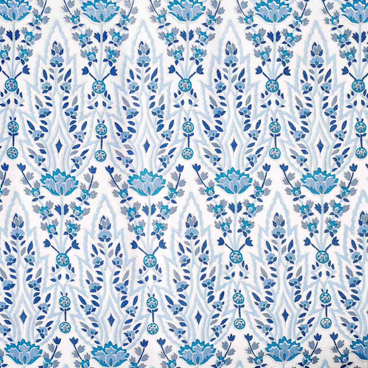 A hand block printed Marmar Turquoise Fabric with a blue and white floral pattern on a crisp white background, inspired by the stunning Mughal gardens in India, created by John Robshaw.