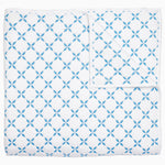 A Layla Azure Quilt by John Robshaw, a cotton voile blue and white blanket with a geometric pattern inspired by Mughal gardens.