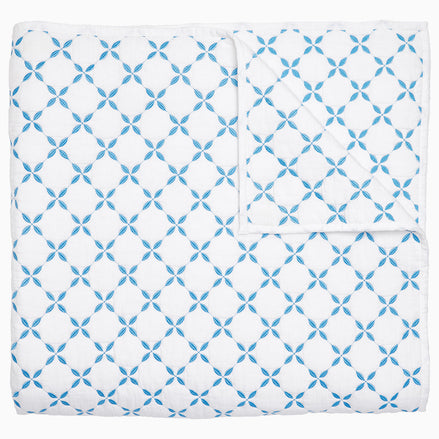 A Layla Azure Quilt by John Robshaw, a cotton voile blue and white blanket with a geometric pattern inspired by Mughal gardens.