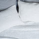 A bed with John Robshaw Organic Hand Stitched Light Indigo Quilt coverlets and blue and white polka dot pillows.