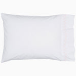 A white pillow with pink piping and embroidered designs on John Robshaw's Stitched Blush Organic Sheets. - 28765998645294