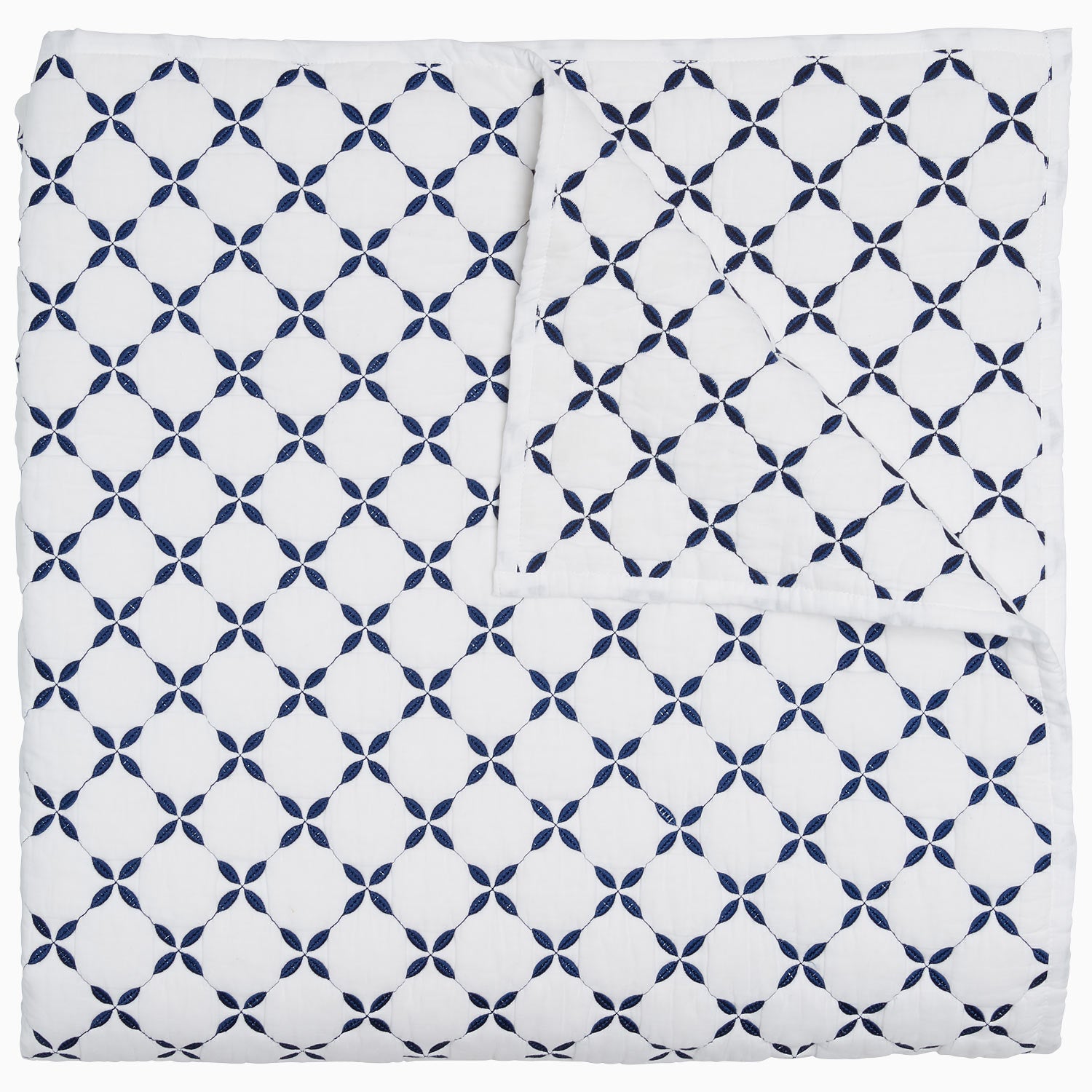 A blue and white Layla Indigo Quilt blanket with a cross design by John Robshaw.