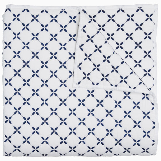 A blue and white Layla Indigo Quilt blanket with a cross design by John Robshaw.