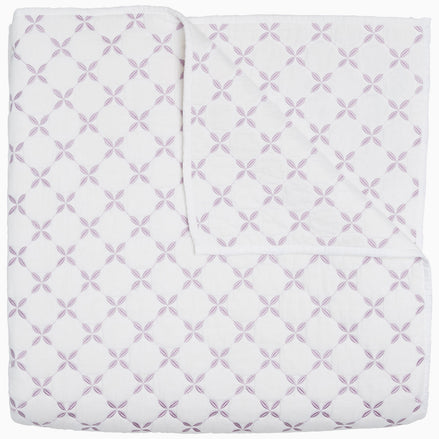 A Layla Lavender quilt by John Robshaw, made from cotton voile, with a cross pattern in white and purple, inspired by Mughal gardens.