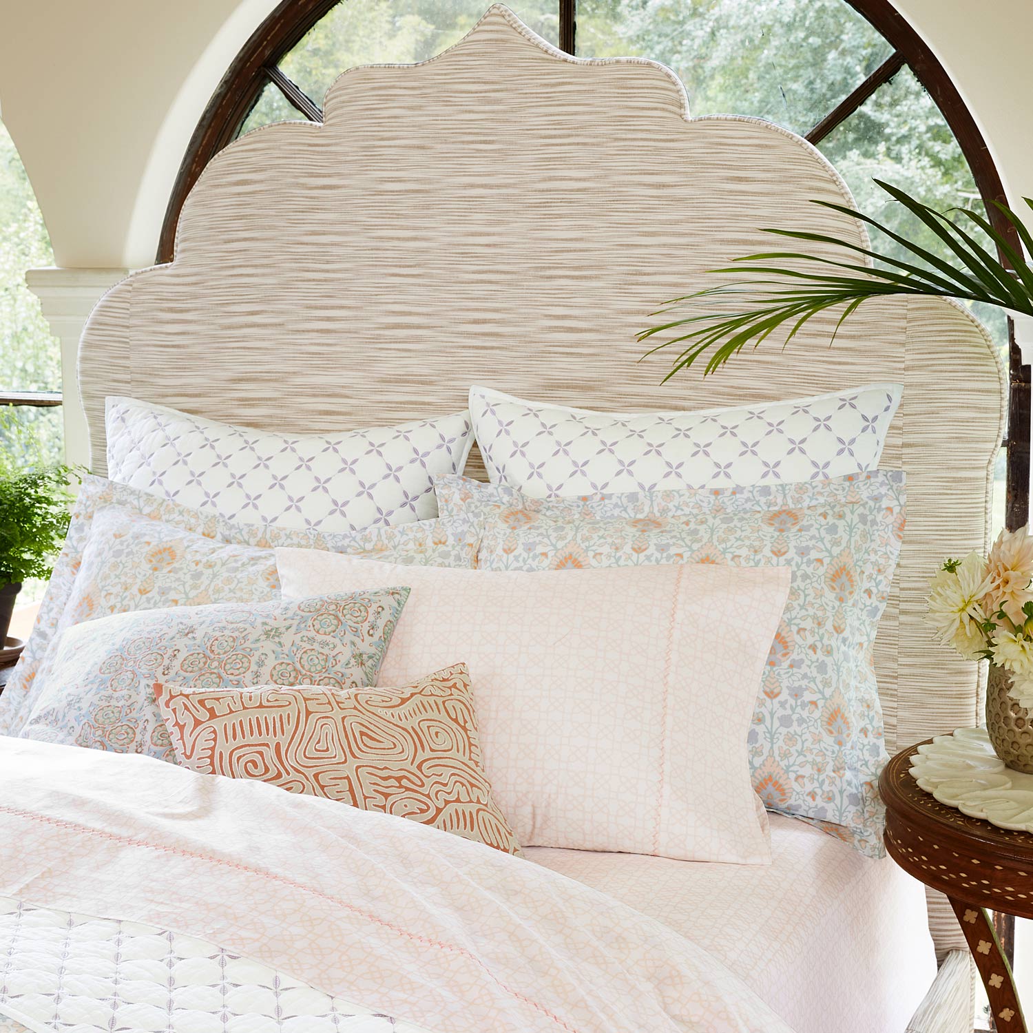 A pink and white Layla Lavender Quilt made of cotton voile, adorned with pillows, inspired by the Mughal gardens, and quilted for extra coziness. (Brand Name: John Robshaw)