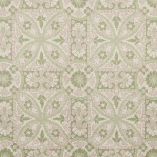 A printed green and white tile pattern with a floral design on John Robshaw's handmade Oman Sage Fabric.