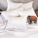 A white bed with pillows and a John Robshaw Layla White Quilt.