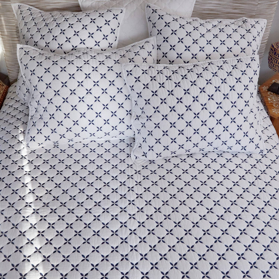 A bed with a Layla Indigo Quilt by John Robshaw, reminiscent of peaceful Mughal gardens.