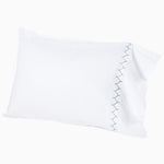 A white pillow with blue embroidered designs on it turned into a Stitched Gray Organic Sheets by John Robshaw. - 30271863652398