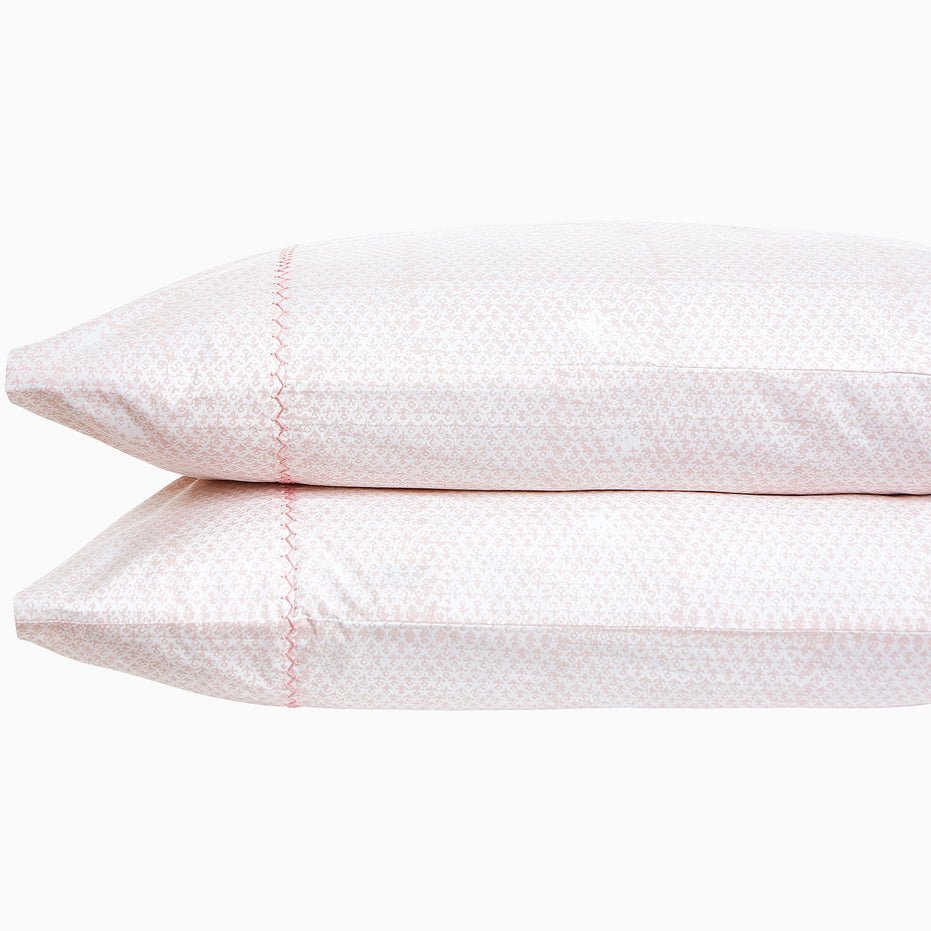 A pair of Poseti Lotus Organic Sheet Sets by John Robshaw, made with organic cotton, resting on a white background. These sheet sets are machine washable.