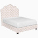 A Custom Bihar Bed by John Robshaw with a pink and gold patterned fabric headboard.