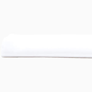 A John Robshaw Organic White Fitted Sheet, made of organic cotton, lying on top of a white surface in India.
